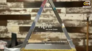 Glass award centered in front of a wood background.