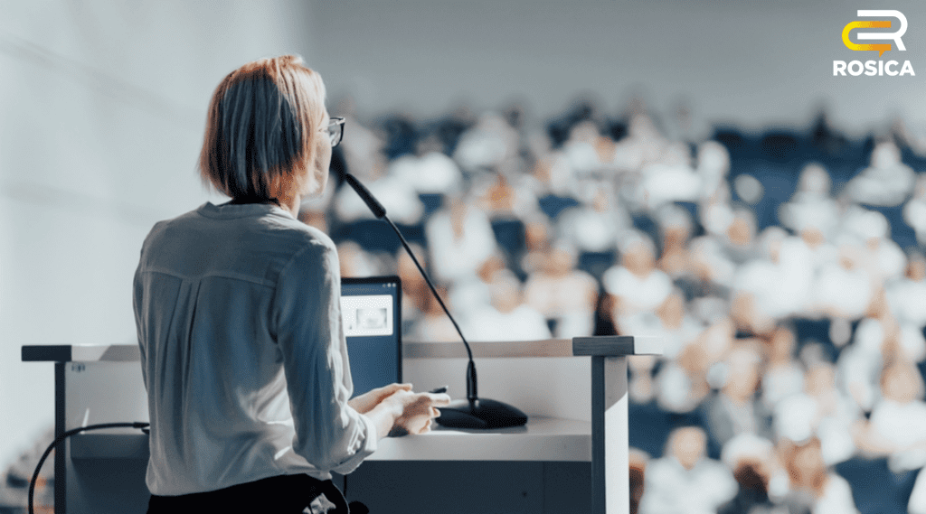 Woman standing in front of a crowd of people giving a speech